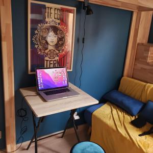 a laptop sitting on a table in a room at Studio cozy - Proche Paris, Métro, salles de concert et Disneyland in Montreuil