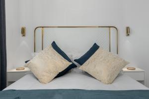 a bed with two pillows on it with two tables at Modern penthouse living Sea Point One26 On M in Cape Town +29 photos