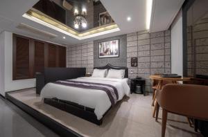 a bedroom with a large bed and a table at Hotel Cube in Incheon