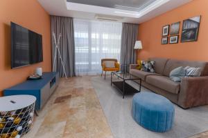 a living room with a couch and a tv at Astria Brasil - Complex Novum in Olimp