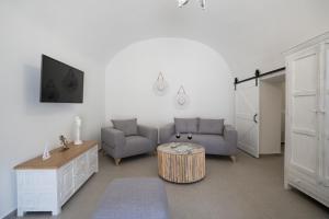 a living room with two chairs and a table at Euphemus Cave House in Mesaria