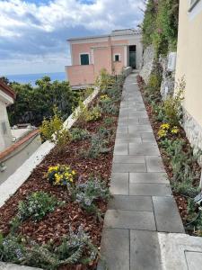 un jardín con flores y una pasarela junto a un edificio en Villa Alba - Smeraldo, en Amalfi