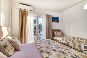 a bedroom with a bed and a window with a balcony at EDEN Sea View rooms in Mali Lošinj