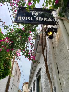 a street sign on the side of a building with flowers at Sidra Hotel in Hydra