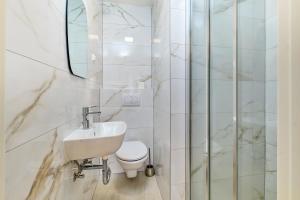 a white bathroom with a toilet and a sink at EDEN Sea View rooms in Mali Lošinj