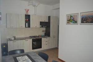 uma cozinha com armários de madeira, uma mesa e uma sala de jantar em Casa al Passaggio em Bettona