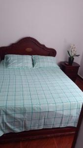 uma cama com um edredão de xadrez azul em Apartamento acogedor en Ibagué em Mirolindo