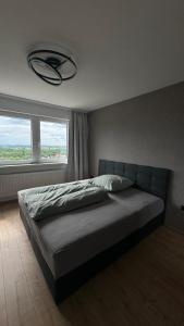 a bedroom with a large bed with a large window at Apartment Weitblick in Braunschweig