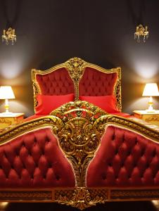 a red and gold bed in a room with two lamps at IRIS baroque apartment in Eleusis