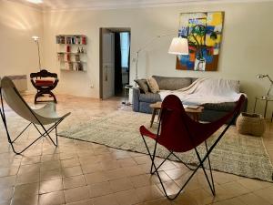 sala de estar con 2 sillas y sofá en La Suite de la Bastide, en Val-de-Dagne