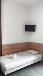a bedroom with a bed with a tv on the wall at Hotel Riviera in Bastia