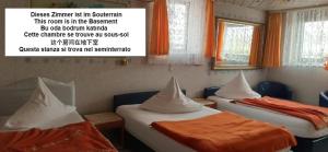 Duas camas num quarto com cortinas cor de laranja em Central Hotel em Schwetzingen
