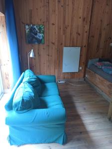 ein Wohnzimmer mit einem blauen Sofa in einem Zimmer in der Unterkunft B&B Halen in Halen