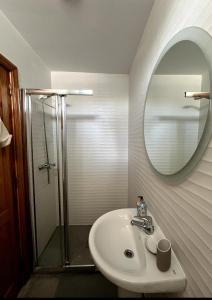 a bathroom with a sink and a shower and a mirror at Céntrico y tranquilo in Costa Teguise