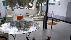 a glass table in a room with a patio at Céntrico y tranquilo in Costa Teguise