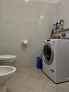 a bathroom with a washing machine and a toilet at Il Casalino, casa centro storico in Montefiascone