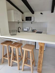 a kitchen with a counter and two stools at Apartmani VERONA in Bijela
