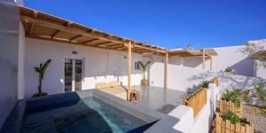 a house with a swimming pool and a patio at Athiri Luxury Suites in Perivolos