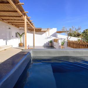 a swimming pool in a villa with a house at Athiri Luxury Suites in Perivolos