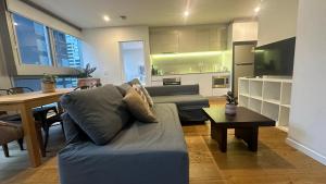 a living room with a couch and a table at Nest Apartments on Rose Lane in Melbourne