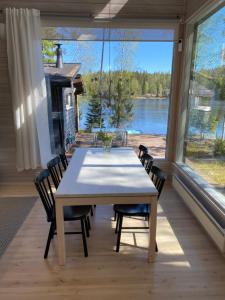 een eetkamer met een tafel en stoelen en een groot raam bij Pirttiranta in Iitiä