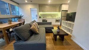 a living room with a couch and a table and a kitchen at Nest Apartments on Rose Lane in Melbourne