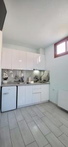 a kitchen with white cabinets and a tile floor at Sunny guest house in Vlorë