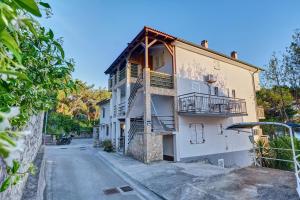 a white building with a balcony on a street at EDEN Sea View rooms in Mali Lošinj
