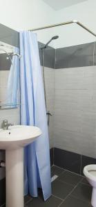 a bathroom with a shower with a sink and a toilet at Sunny guest house in Vlorë