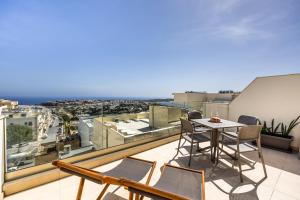 d'un balcon avec une table et des chaises et une vue. dans l'établissement Fl7 Thelodge-stunning Views With Spacious Terrace, à Mellieħa