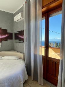 um quarto com uma cama e vista para o oceano em B&B Villa Magna Grecia em Lazzaro