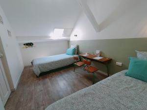 a small room with two beds and a desk at L'école buissonnière in Laroque-dʼOlmes