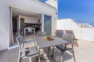 d'une salle à manger avec une table et des chaises sur un balcon. dans l'établissement Fl7 Thelodge-stunning Views With Spacious Terrace, à Mellieħa