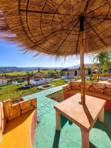a wooden bench under an umbrella on a patio at LA GRANJA in Tétouan