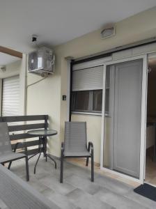 einen Balkon mit 2 Stühlen, einem Tisch und einem TV in der Unterkunft Nikos house studios in Ofrynio