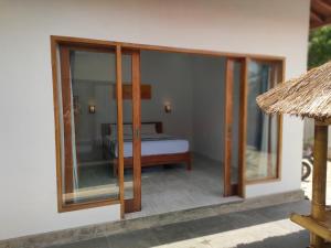 Habitación con cama y puertas correderas de cristal en Vera Koe, en Kuta Lombok