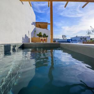 a swimming pool with blue water in a house at Athiri Luxury Suites in Perivolos