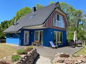 Cette maison bleue dispose d'une terrasse couverte. dans l'établissement Ferienhaus am Gutspark 3, Klausdorf, ca 250 m bis zur Badestelle, à Klausdorf