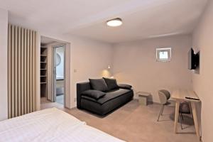 ein Schlafzimmer mit einem Bett und einem Sofa in einem Zimmer in der Unterkunft Hotel Kavalír in Karlsbad