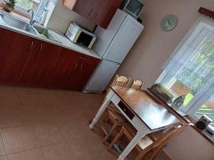 a kitchen with a table and chairs and a refrigerator at Pokoje Augustowskie in Augustów +6 photos