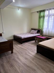 a room with two beds and two tables in it at BLUE DUKE HOMESTAY in Ravangla