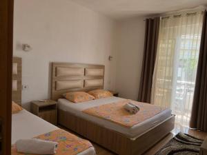 ウルツィニにあるKontiki Apartmentsのベッドルーム1室(ベッド2台、ベッド上にテディベア付) +2枚の写真