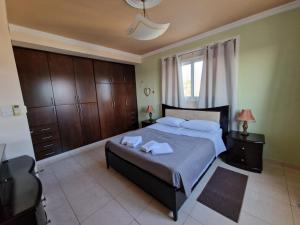 a bedroom with a bed with two towels on it at Family House in Paphos City