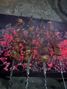 a bunch of meat cooking on a grill at Linda Guest house in Batumi