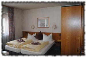 ein Schlafzimmer mit einem großen Bett mit zwei Kissen in der Unterkunft Gasthof Stern in Burgsinn