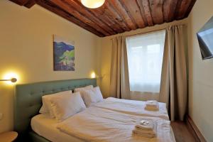 Schlafzimmer mit einem Bett mit weißer Bettwäsche und einem Fenster in der Unterkunft Hotel Kavalír in Karlsbad