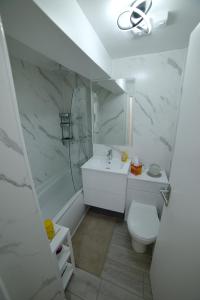 a white bathroom with a sink and a toilet at Modern Garden Flat Close To Beach in Eastbourne +16 photos