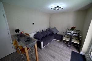 a living room with a couch and a table at Modern Garden Flat Close To Beach in Eastbourne