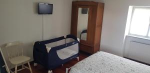 een kamer met een bed, een stoel en een tv bij Appartamento CasaMia in Miasino