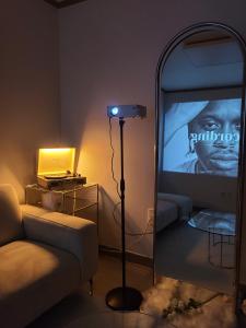 a living room with a mirror and a television at Torry House in Busan